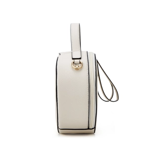 Detail showing cross-grain leather texture and gold hardware on cream circular handbag