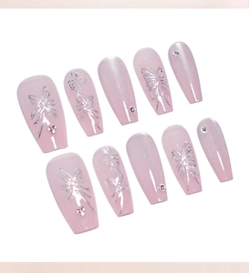 Detail of pink cat eye press-on nails with silver butterfly patterns and rhinestones