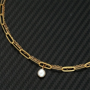 Close-up of golden double-layer stainless steel necklace with a white baroque pearl