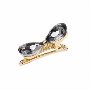 Elegant gold bow hair clip featuring two grey teardrop crystal stones on white background