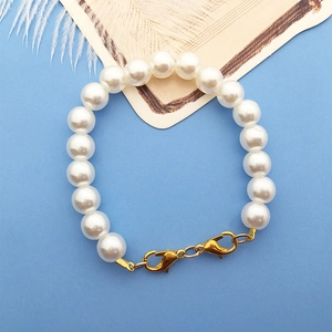 Detail of white pearl bracelet with golden lobster clasps on light blue background