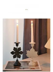 Macro detail of metal candle holders with matte finish and delicate leaf design