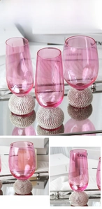 Vue détaillée d'un verre à vin rose de luxe avec une base sphérique en strass argentés