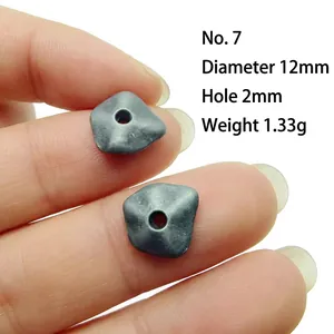 Detailed view of 12mm dark gray irregular geometric alloy spacer bead held by fingers