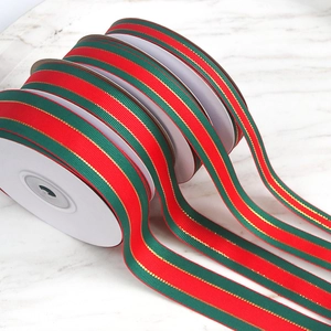 Detail of red and green striped grosgrain ribbons with gold edges on marble