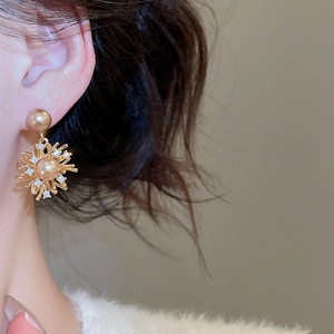 Dettaglio di orecchini a girasole placcati oro 18K con perle e cristalli su modella