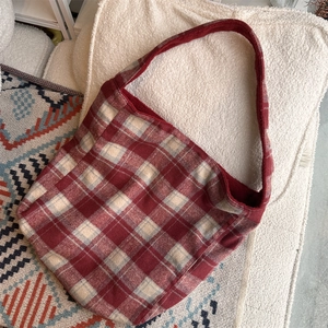 Detail of red and cream plaid tote bag in soft woolly fabric for autumn and winter