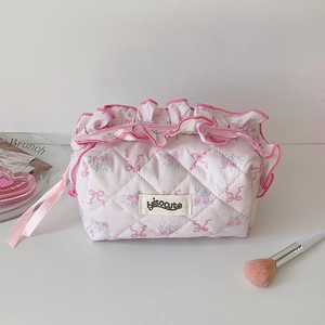 Detail of pink quilted floral cosmetic bag with lace trim and ribbon handle