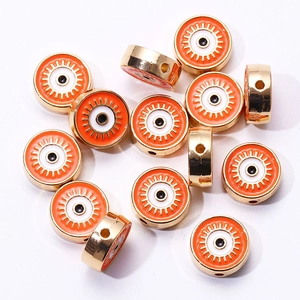 Détail macro de perles en émail œil porte-bonheur orange et or pour bijoux DIY