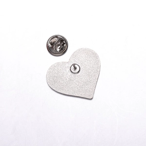 Detail of silver heart-shaped metal badge back with secure butterfly clutch pin