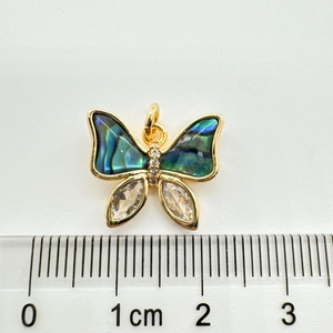 Macro d'un pendentif papillon en or 18 carats avec ailes en nacre et détails en zircon