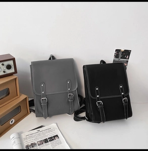 Detail of vintage gray and black PU leather backpacks with stylish contrast stitching