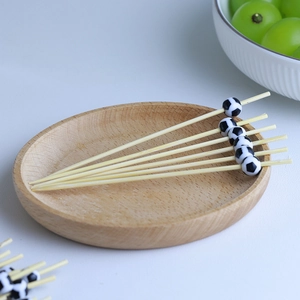 Macro shot of bamboo fruit picks featuring black and white soccer ball toppers