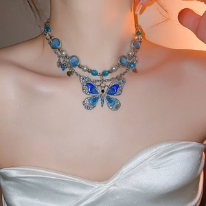 Vue détaillée d'un collier papillon double couche avec des perles bleues et cristaux
