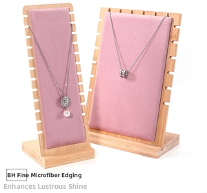 Detail of pink microfiber and wood display stand showing jewelry hanging slot features