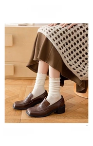 Detail of cream white knit crew socks with ruffled edges shown on model in retro setting