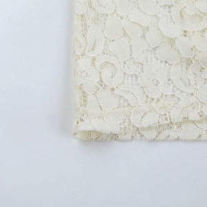 Close-up of the delicate floral lace pattern on a white bodycon slip dress for women