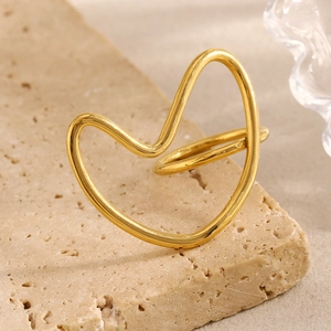 Abstract hollow gold heart line ring displayed on a natural stone textured background