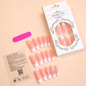 Flat lay of pink gradient press-on nails with 3D butterfly, pearl, and flower accents