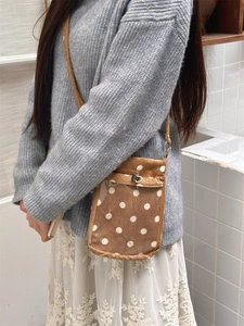 Detailansicht der braunen Cord-Umhängetasche mit Polka Dots und transparentem PVC-Fach