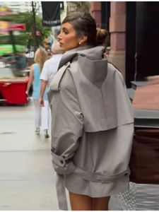 Detail view of the back wind flap and belt on this light grey double-breasted trench coat