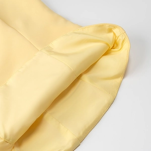 Vue détaillée du tissu plissé jaune clair montrant les coutures fines et la doublure