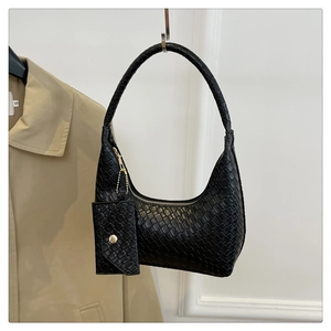 Detail view of black woven shoulder bag with small coin purse and golden hardware