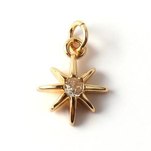Macro shot of gold-plated octagonal star pendant with a sparkling center zircon stone