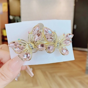 Pink crystal butterfly hair clip with golden alloy frame on handmade jewelry card