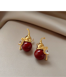 Detailed macro view of gold-plated gourd earrings with red beads and heart zirconia