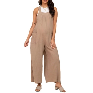 Detail of light khaki maternity jumpsuit showing cotton linen fabric texture and wide legs
