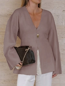 Detail of elegant dusty pink V-neck sweater with a single gold button closure and soft fabric