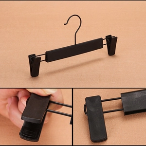 Adjustable black plastic pants hanger with metal hook and non-slip clips for laundry