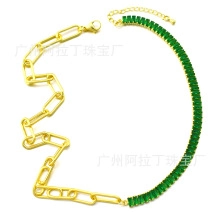 Detail of a half-gold chain and half-green zircon link necklace with lobster clasp