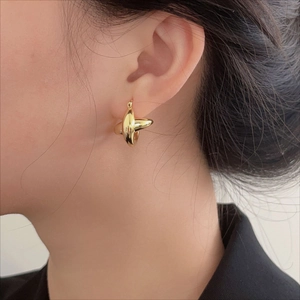 Elegant 925 sterling silver gold-plated crossover hoop earrings worn by a model