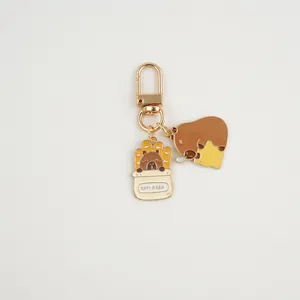 Close-up of golden metal Capybara keychain with cute charms on a clean background