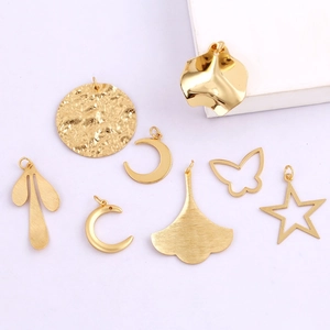 Flat lay detail of gold-plated moon, butterfly, and leaf DIY jewelry charms
