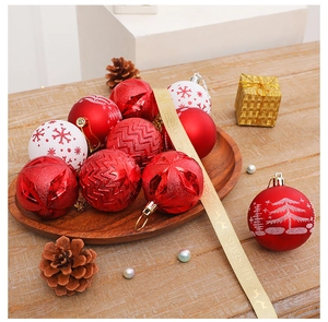 Détail de boules de Noël rouges et blanches avec motifs pailletés sur plateau bois