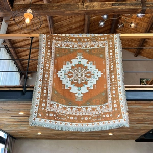 Detailed view of bohemian woven blanket with tribal patterns and decorative fringes