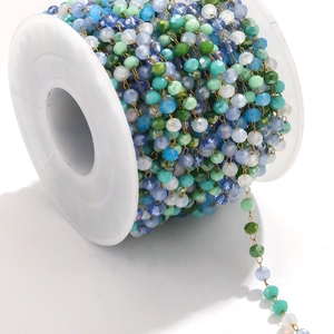 Close-up of mixed color faceted crystal bead chain on gold spool for DIY jewelry