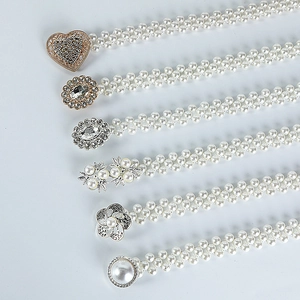 Detail view of six pearl waist chains with various gold and silver rhinestone buckles