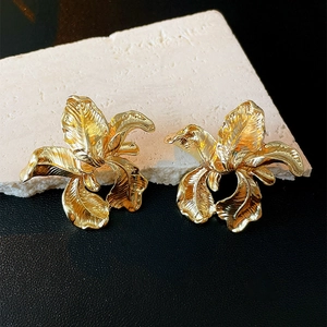 Detailed view of golden irregular flower stud earrings with vintage metal texture
