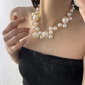 Close-up of bohemian cluster pearl necklace on neck showing mixed sizes and lustrous finish