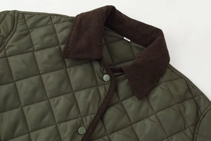 Détail de la veste matelassée vert armée avec col en velours côtelé marron et pressions
