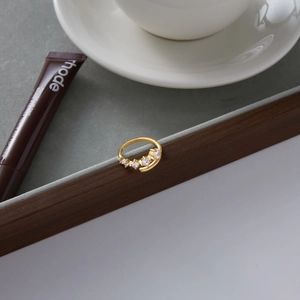 Detail of gold-plated open ring featuring five round white cubic zirconia stones