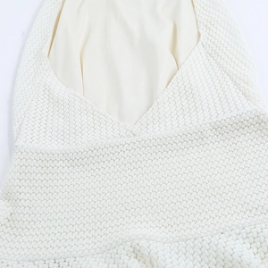 Close-up of the white textured knit fabric and breathable hollow-out mesh detail