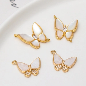 Detail of gold-plated butterfly charms with zircons and mother of pearl for DIY jewelry