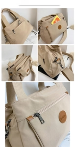 Detail view of khaki nylon handbag featuring multiple metal zippers and removable strap