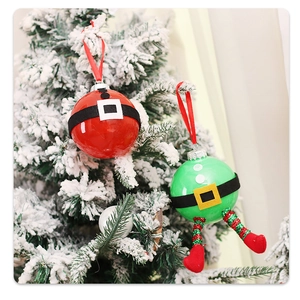 Detail of Santa and elf Christmas ornaments hanging on a snowy festive tree branch