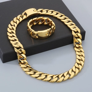 Detailed view of 24mm gold hip hop Cuban chain necklace and bracelet set on box